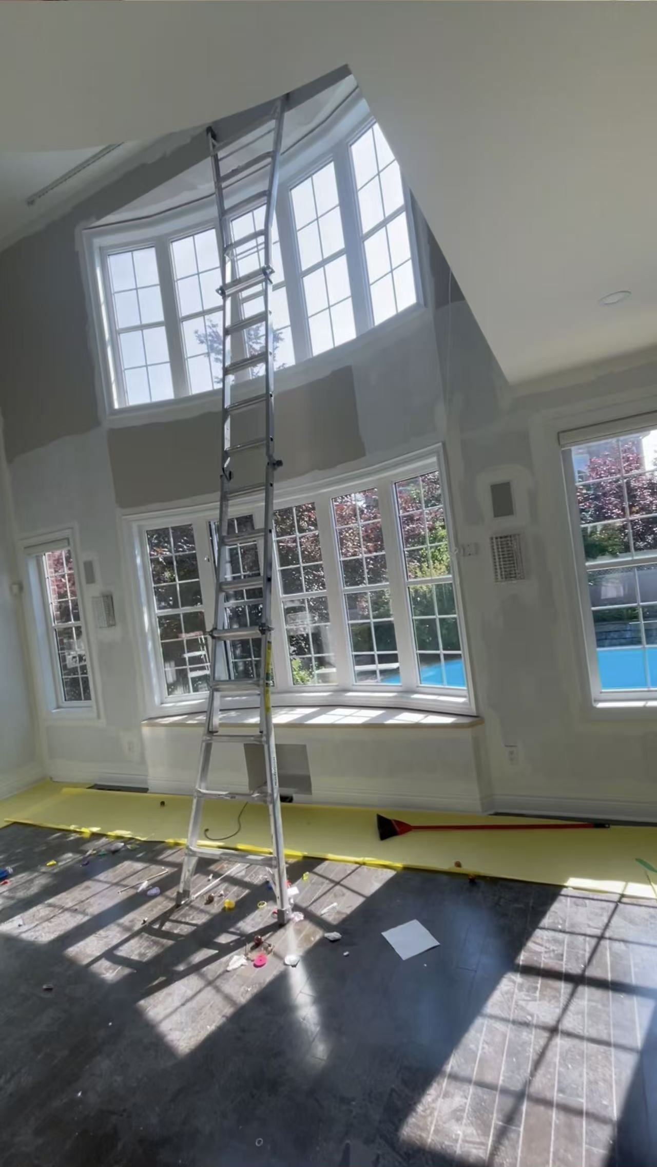 Interior painting preparation with protected floors and a ladder